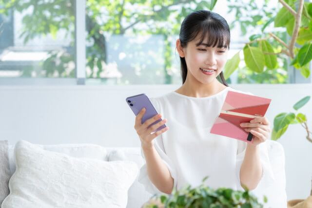 ネット銀行特定のため通帳の振込履歴を確認する女性