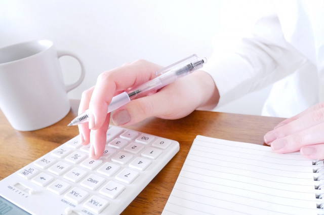 電卓を使って会社設立にかかる法定費用を計算する様子